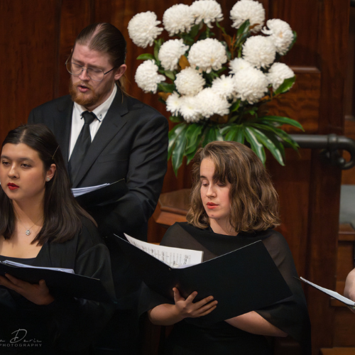 Pacific Opera Studio chorus dressed in black, singing in St Stephen's Anglican Church